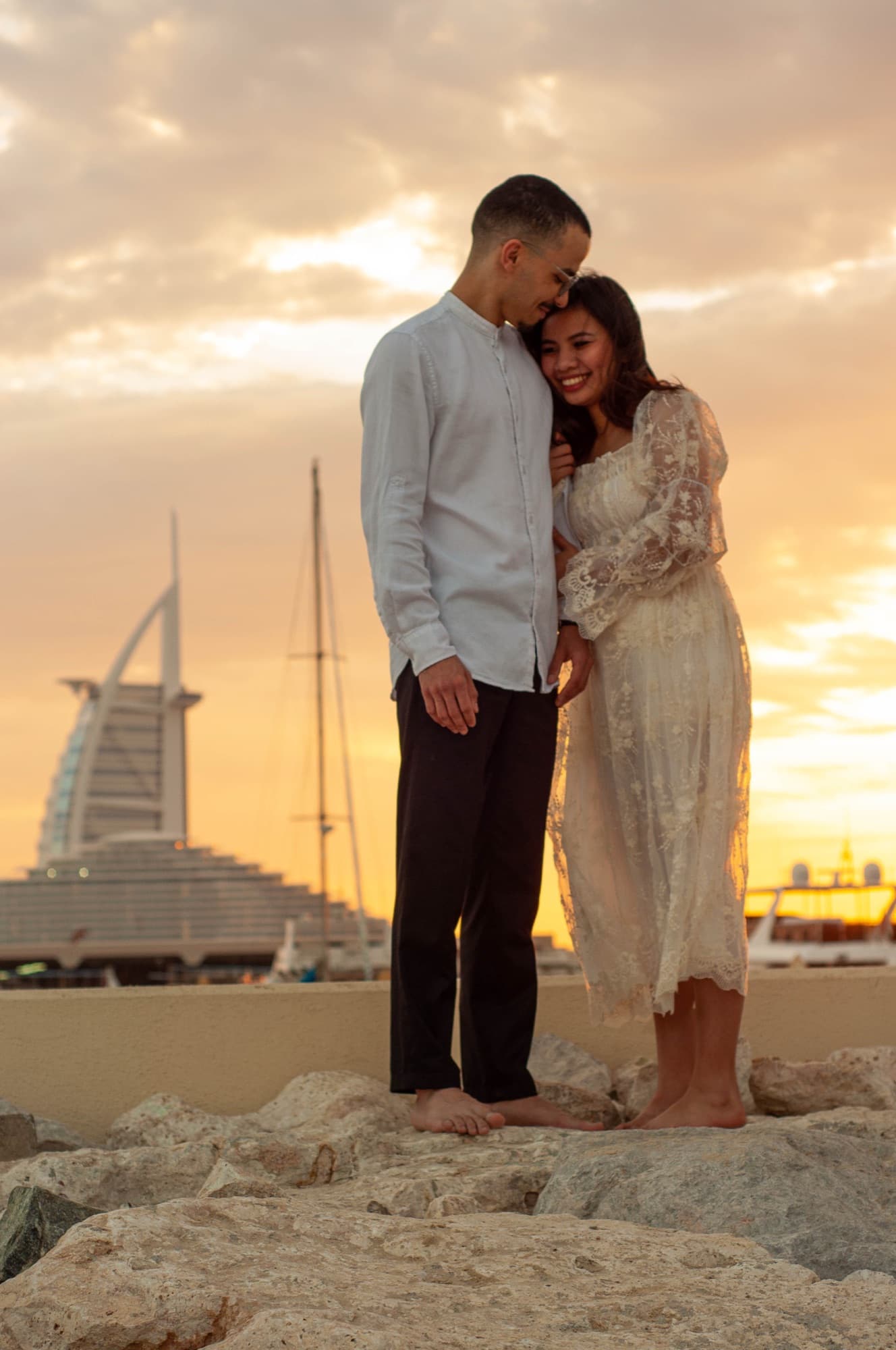 Couple on the beach at sunset below the Burj Al Arab