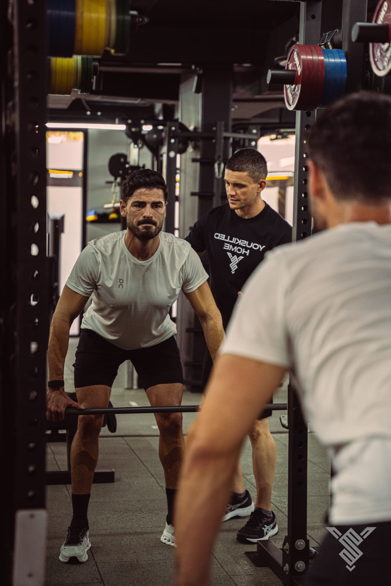 Coach watching a client squat at Youskilled