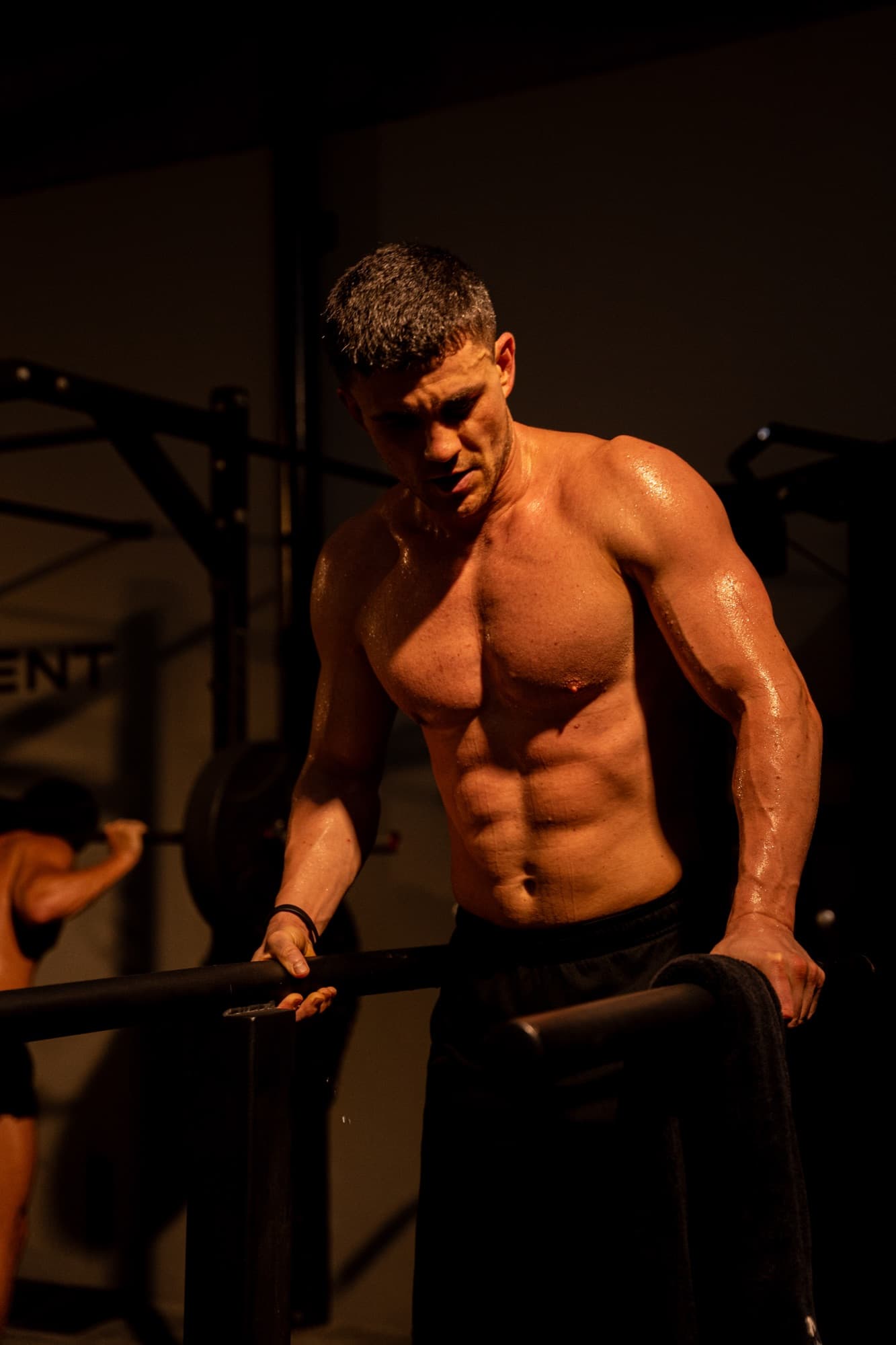 Shirtless athlete under warm light at Youskilled