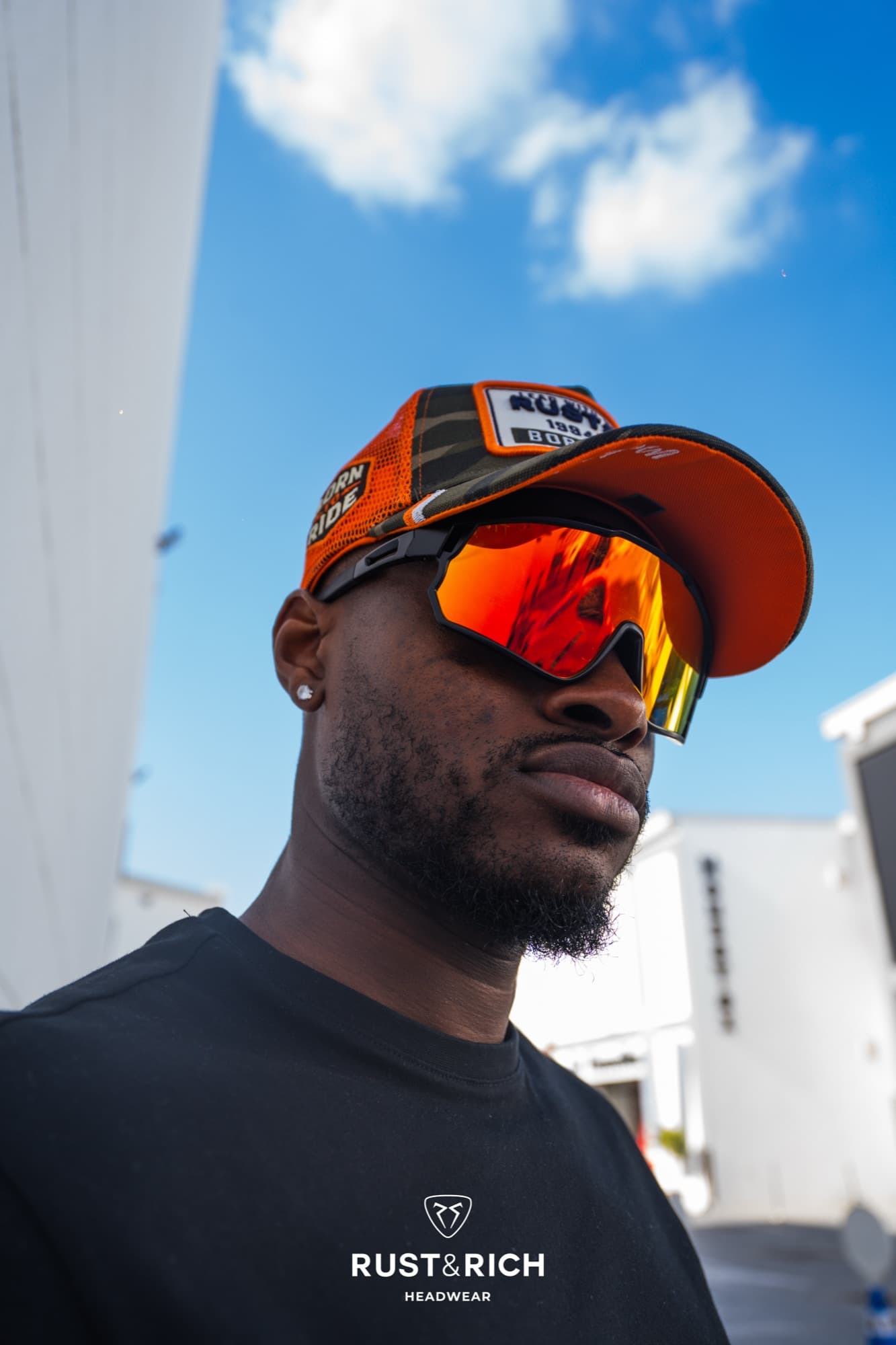 Rust and Rich campaign portrait in a cap and mirrored sunglasses