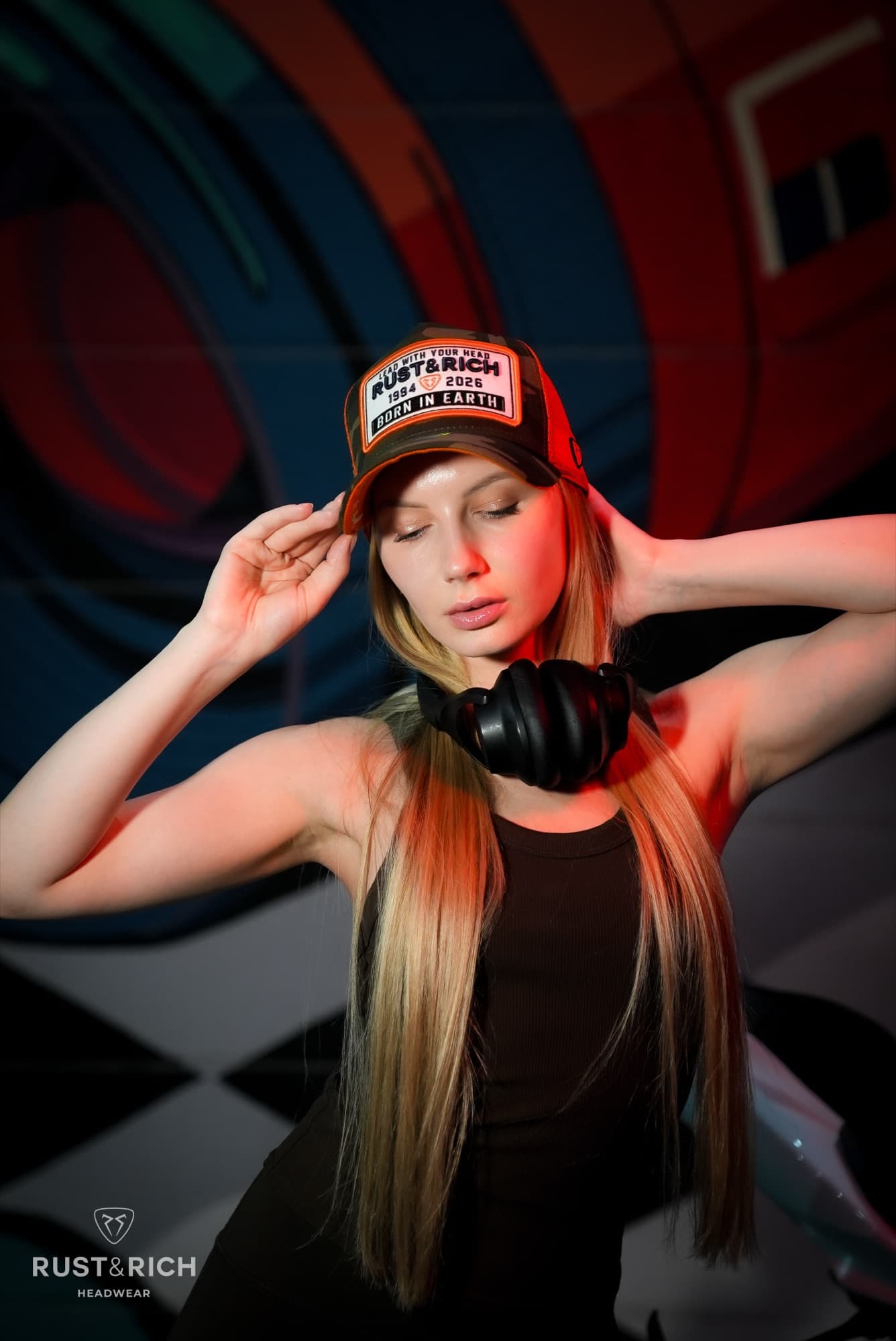 Model adjusting a branded cap on a checkered set