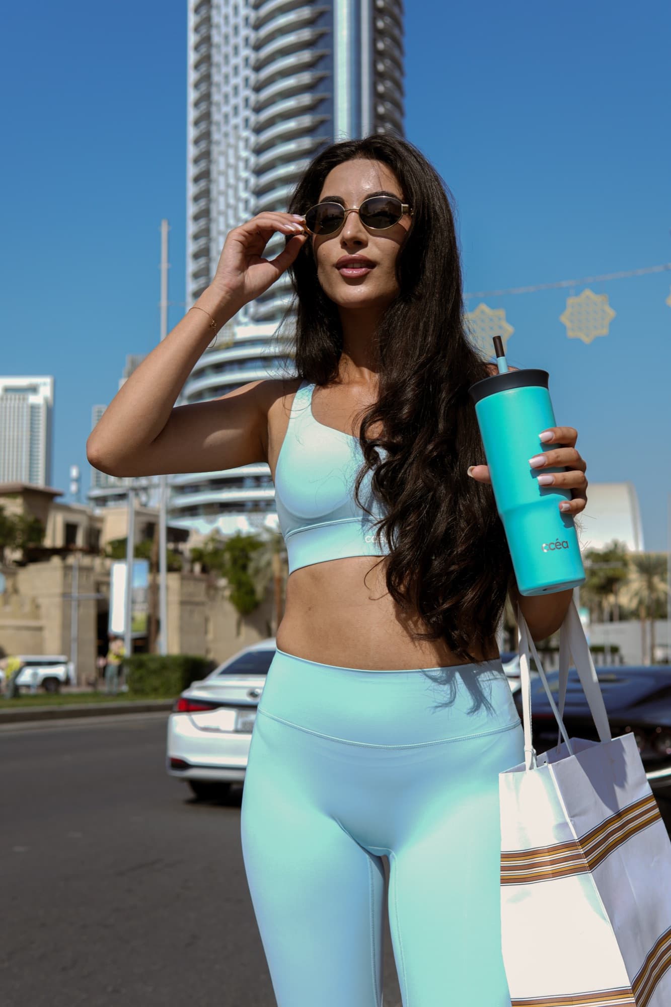 Model in CCEA activewear carrying a tote on a city street
