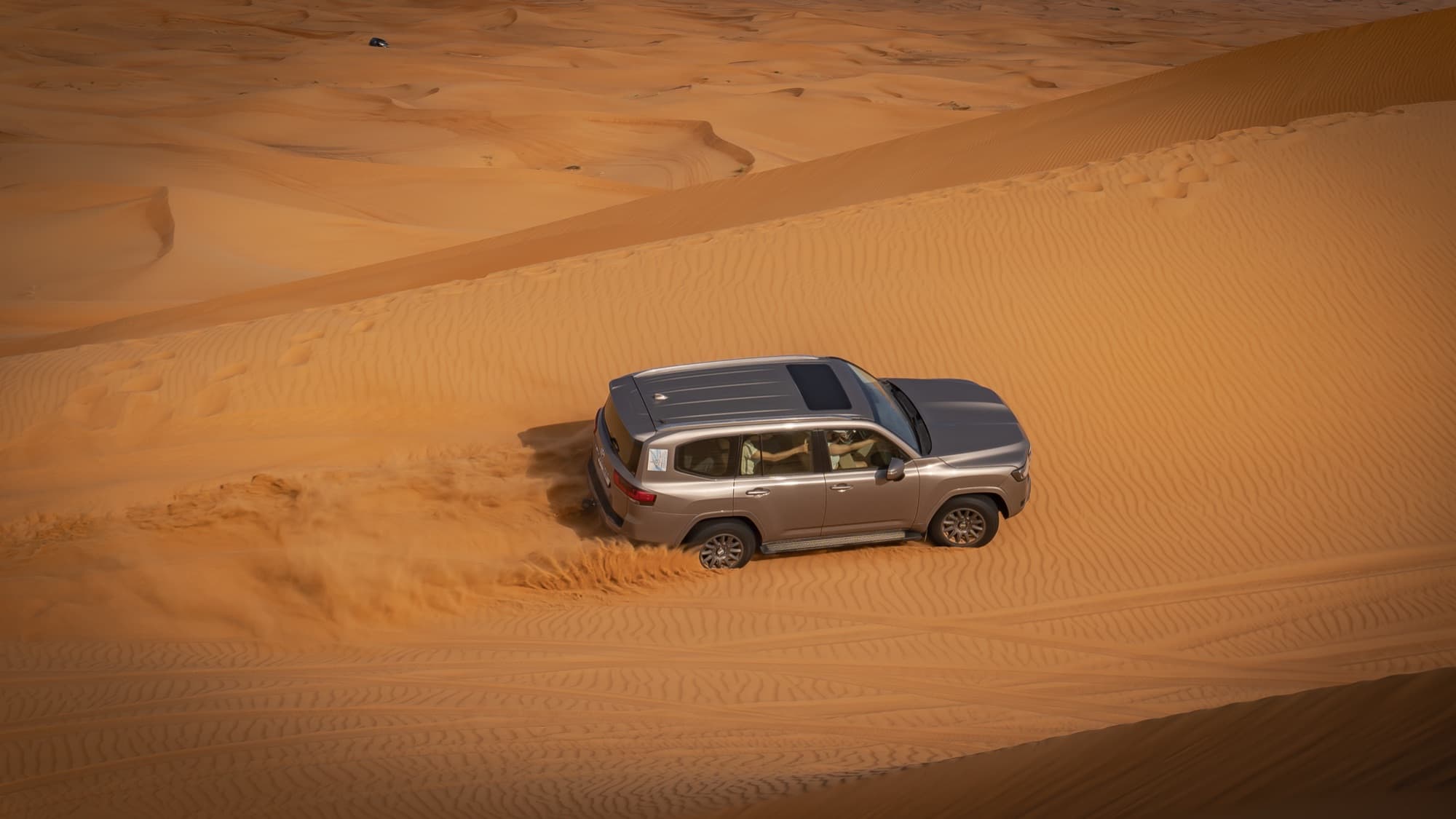 Four-wheel drive cresting a desert dune